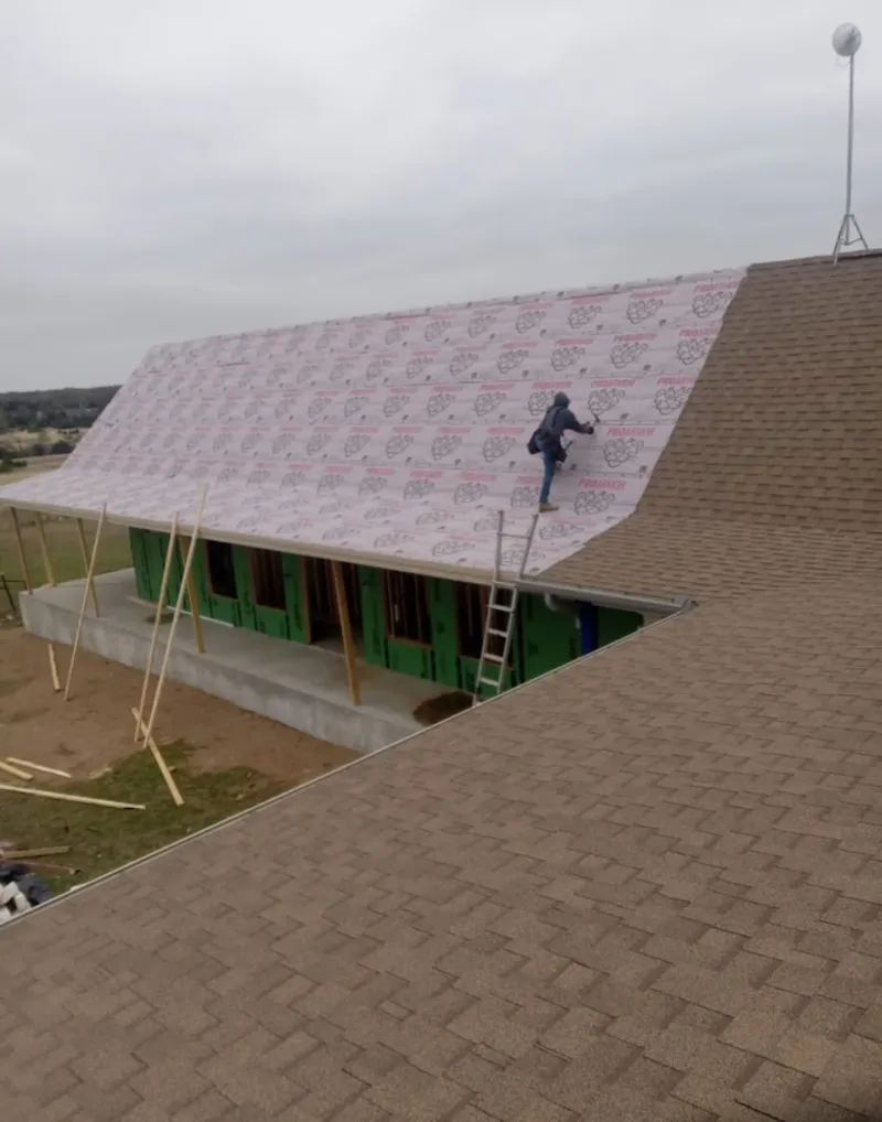Worker preparing underlayment for a metal roof installation in Glenwood Springs